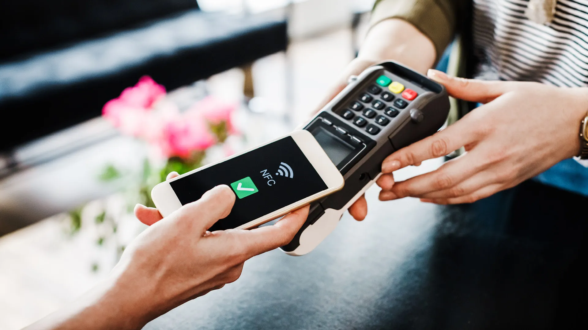a person using a phone to pay for a credit card a person using a phone to pay for a credit card